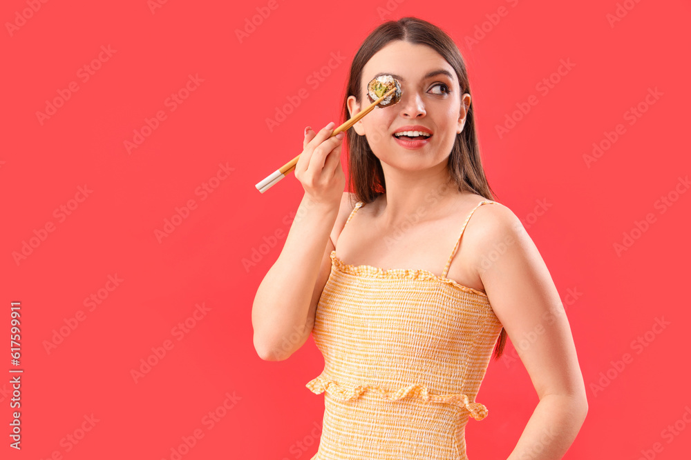 Young woman with sushi roll on red background