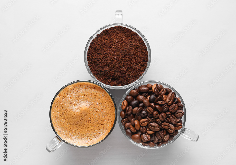 Cups of hot espresso and coffee beans on white background