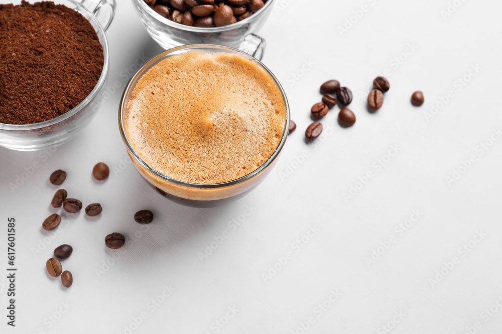 Cups of hot espresso and coffee beans on white background