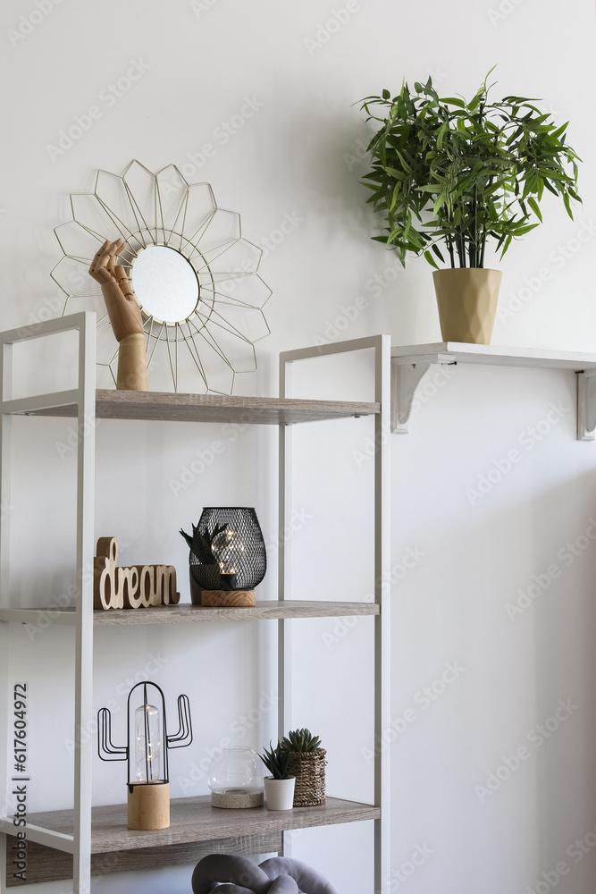 Shelving unit with glowing lamps and decor in light room