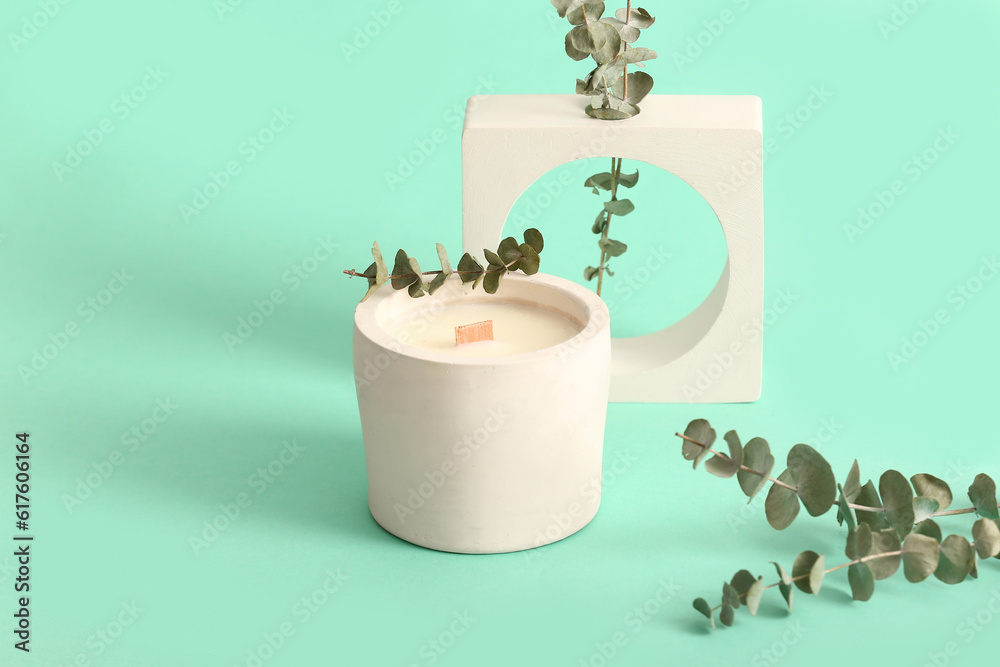 Holder with candle and decorative podium on turquoise background