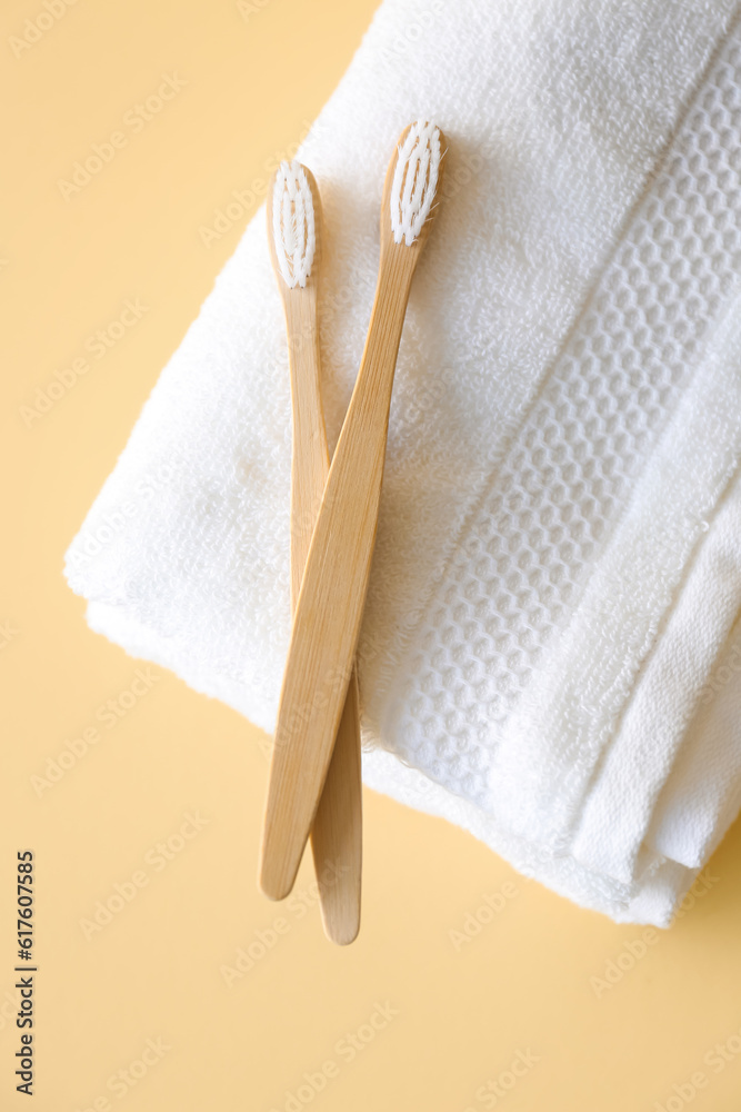 Bamboo tooth brushes and towels on beige background