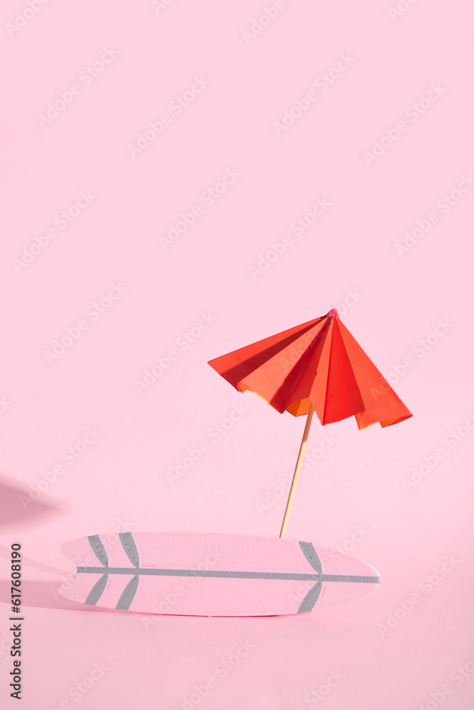 Mini surfboard with umbrella on pink background