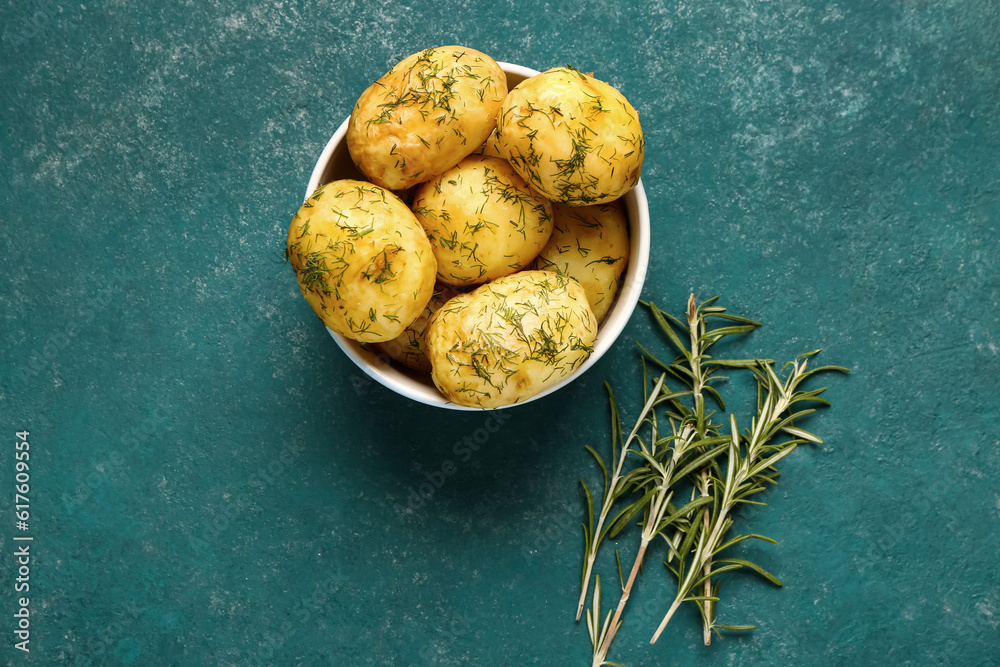 Bowl of boiled baby potatoes with dill and rosemary on blue background