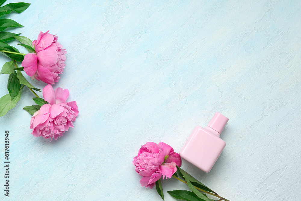 Composition with bottle of perfume and beautiful peony flowers on light blue background