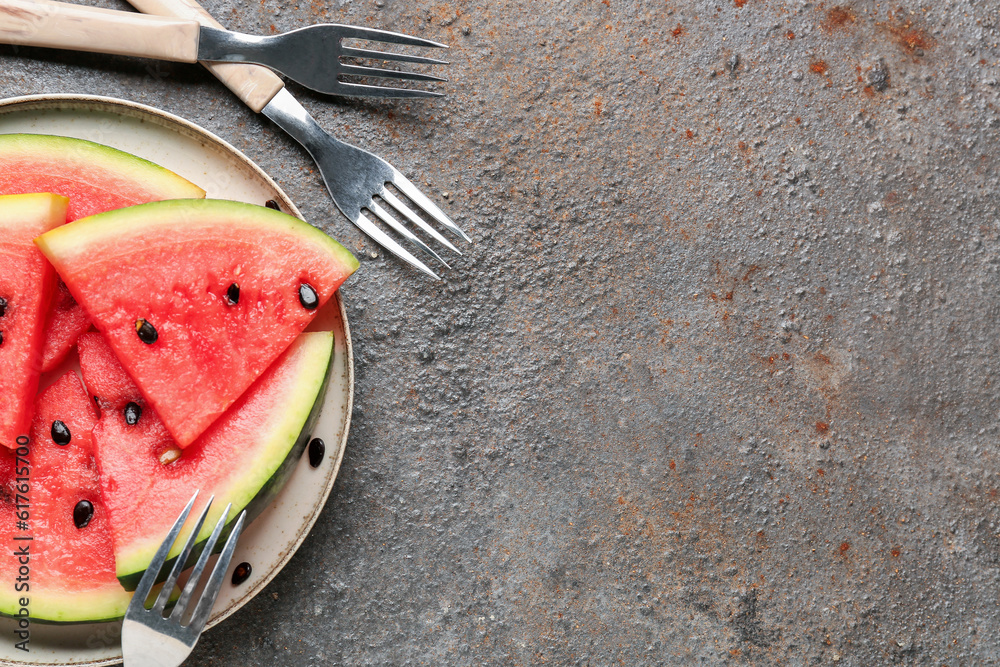 Plate with pieces of fresh watermelon and seeds on dark background