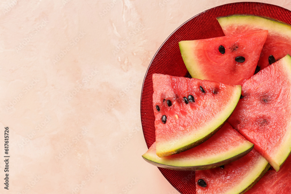 Plate with pieces of fresh watermelon on pink background