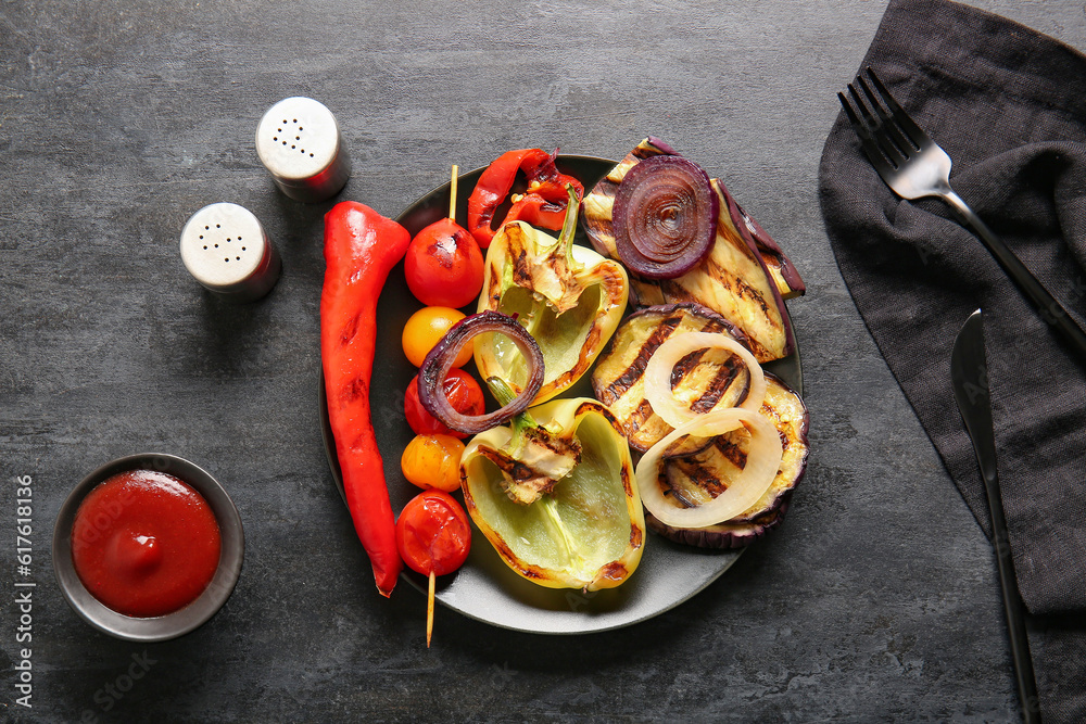 Plate with tasty grilled vegetables and sauce on black background