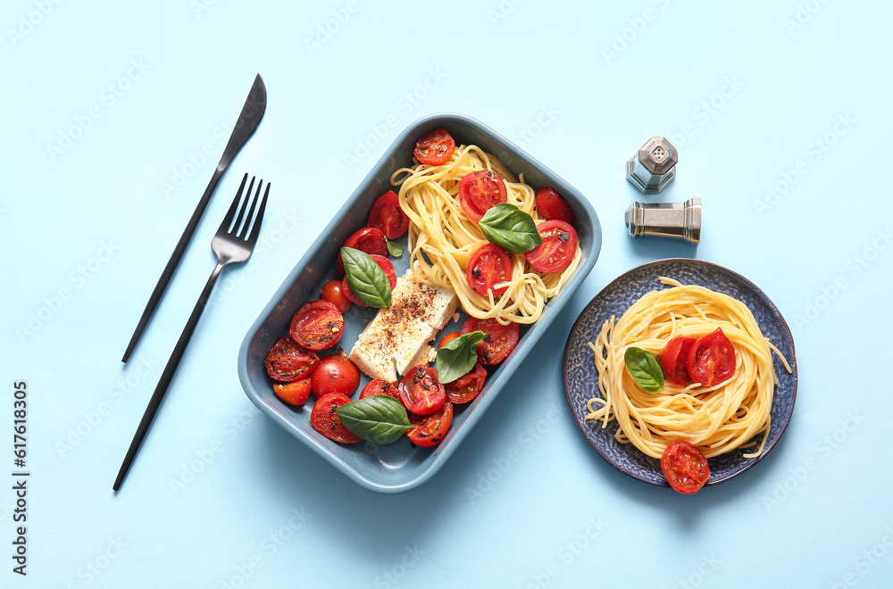 Baking dish with tasty tomatoes, feta cheese and pasta on blue background