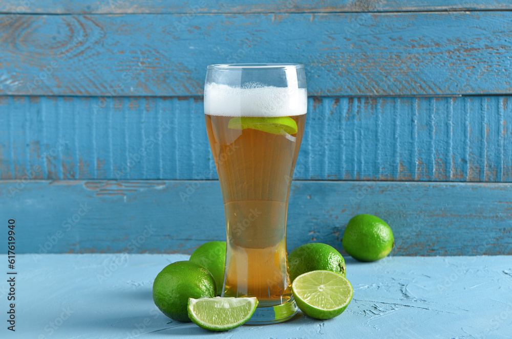 Glass of cold beer with lime on table