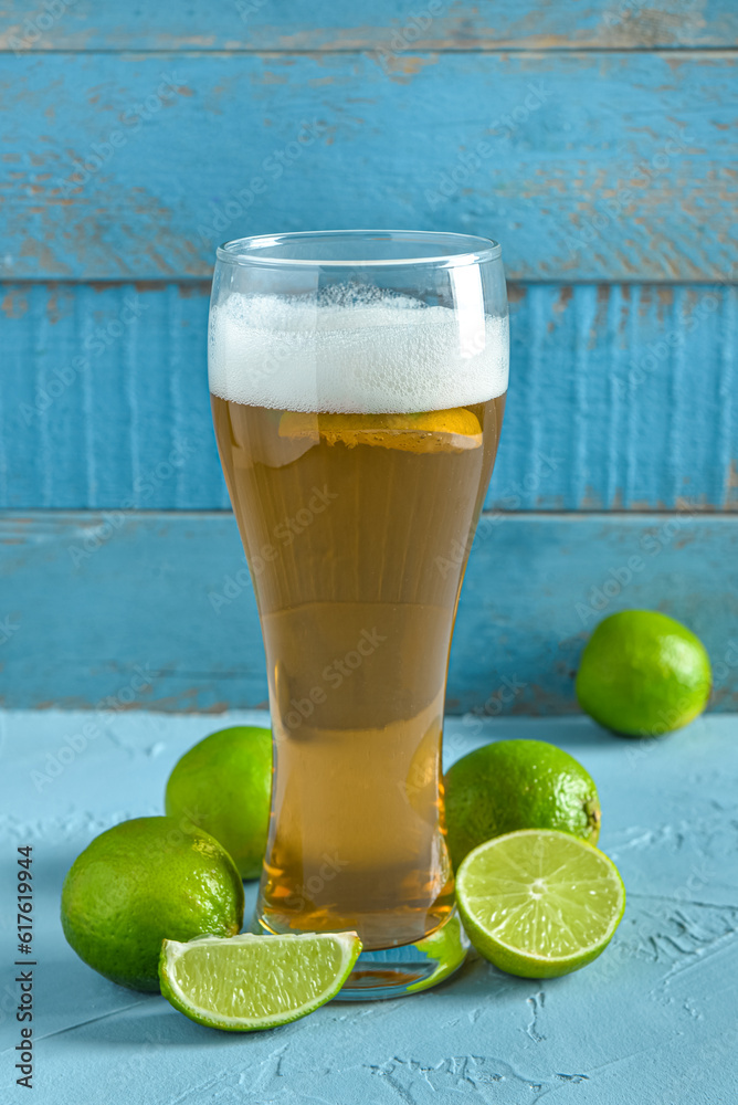 Glass of cold beer with lime on table