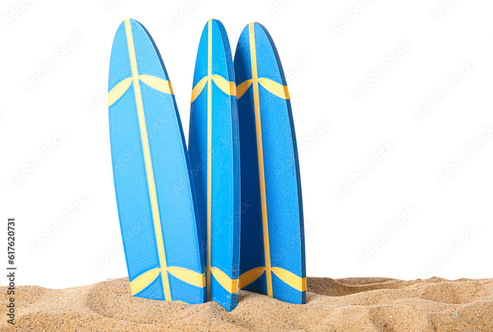 Mini surfboards on sand against white background