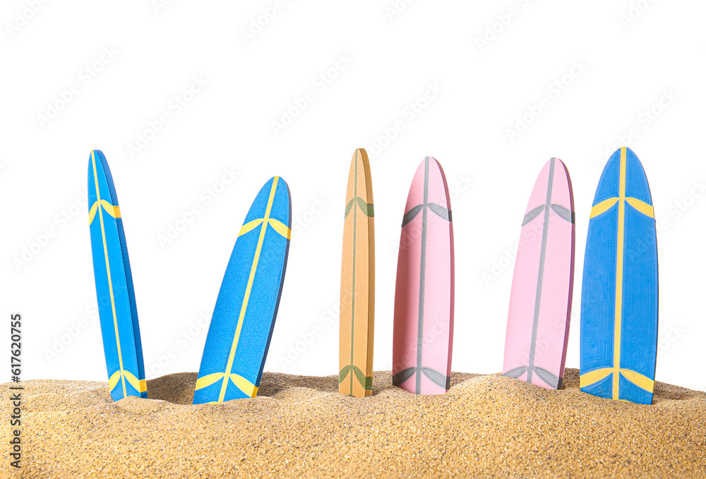 Different colorful mini surfboards on sand against white background