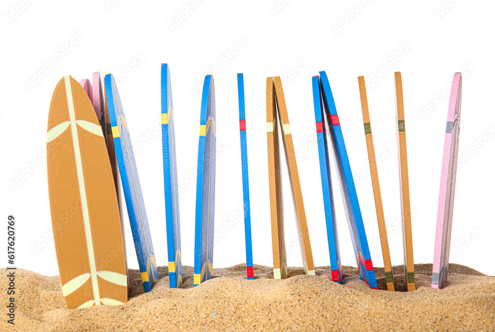 Different colorful mini surfboards on sand against white background