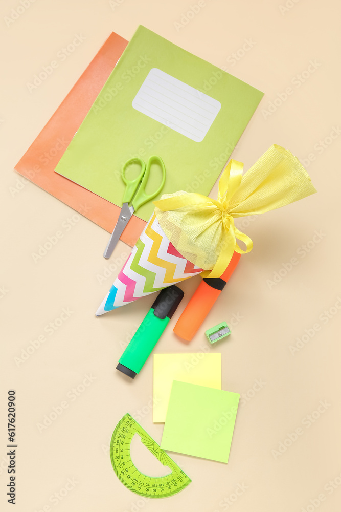 Yellow school cone with different stationery on pale orange background