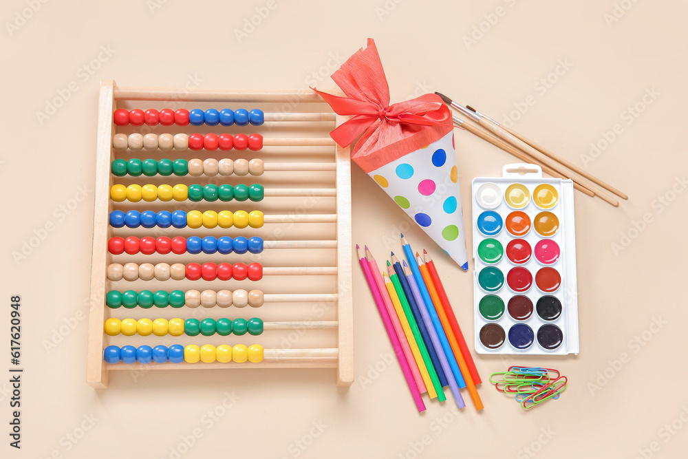 Red school cone with abacus and different stationery on pale orange background