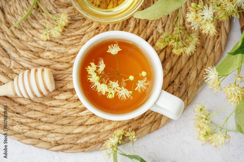 Cup of linden tea on white background