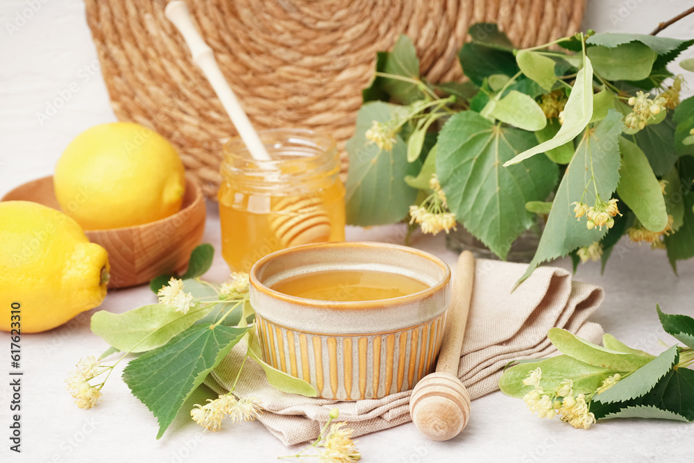 Bowl and jar with linden honey on white background