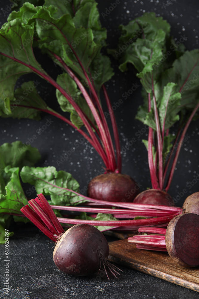 Wooden board with fresh beets on table