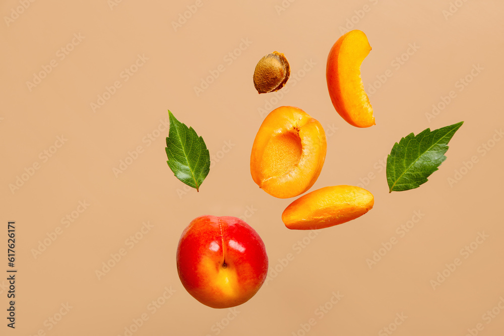 Flying fresh apricot with pieces and leaves on orange background