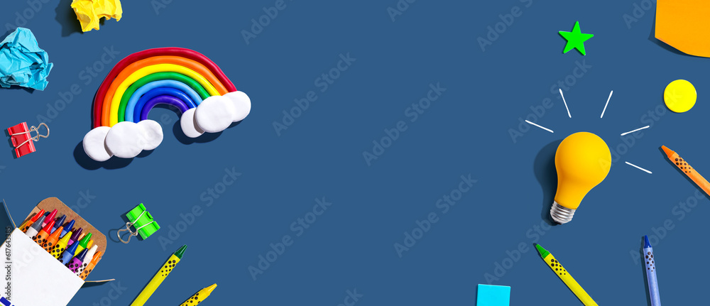 Idea light bulb with a rainbow and school supplies overhead view - flat lay