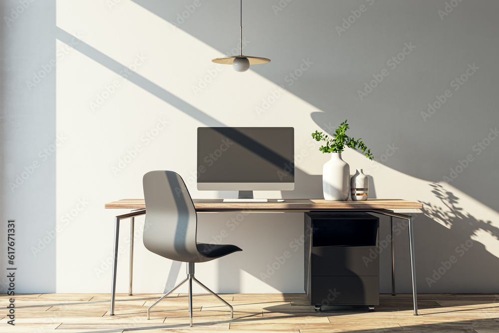 Modern home office interior with computer, furniture and other items. Concrete wall with shadows and