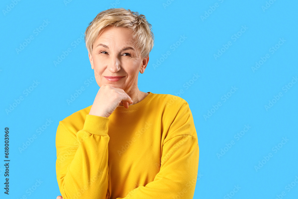 Dreaming mature woman on blue background