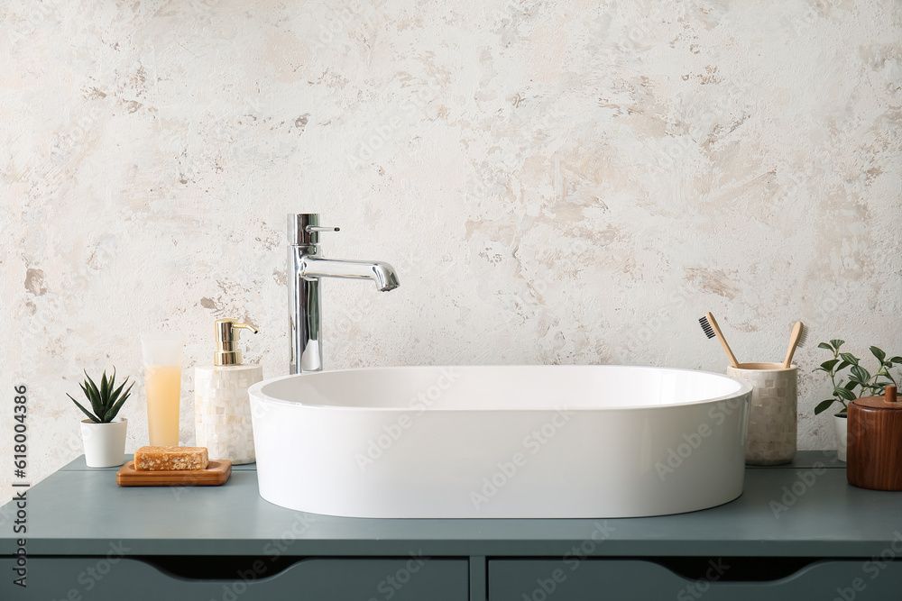 White sink with bath accessories on table in room