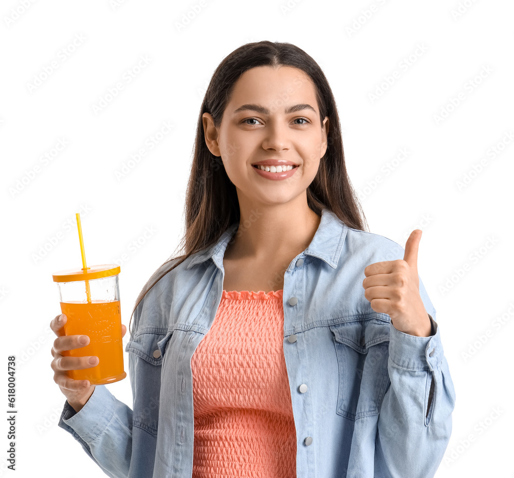 Young woman with glass of vegetable juice showing thumb-up on white background