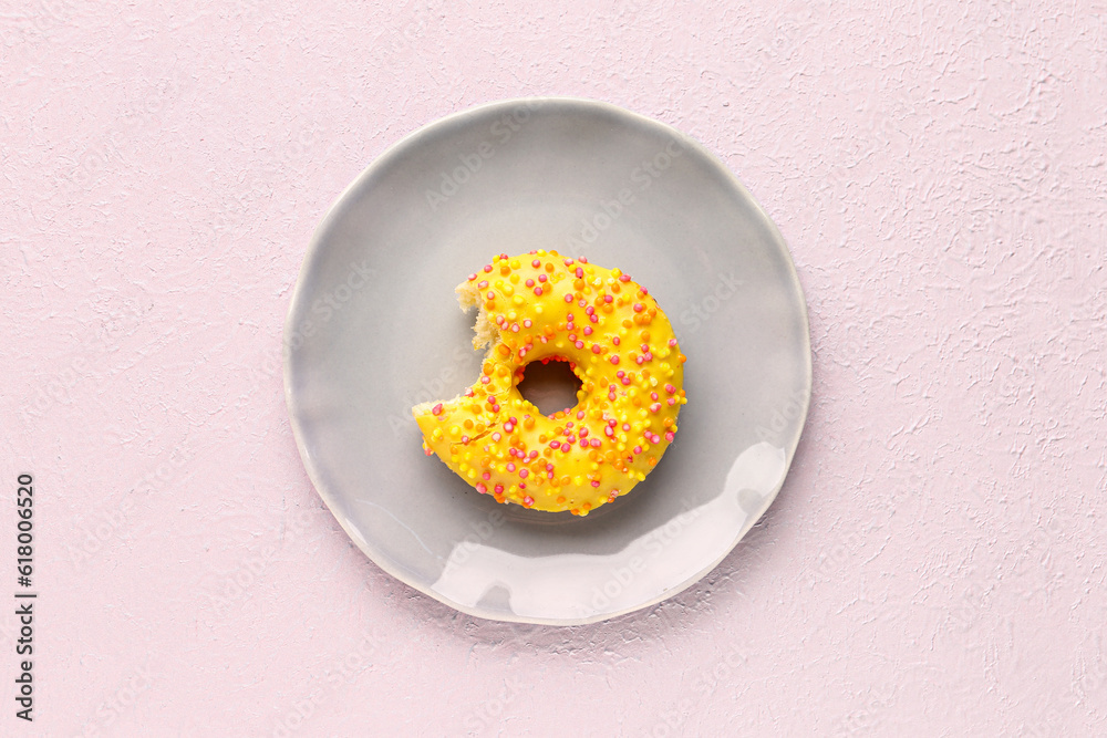 Plate with sweet donut on light background