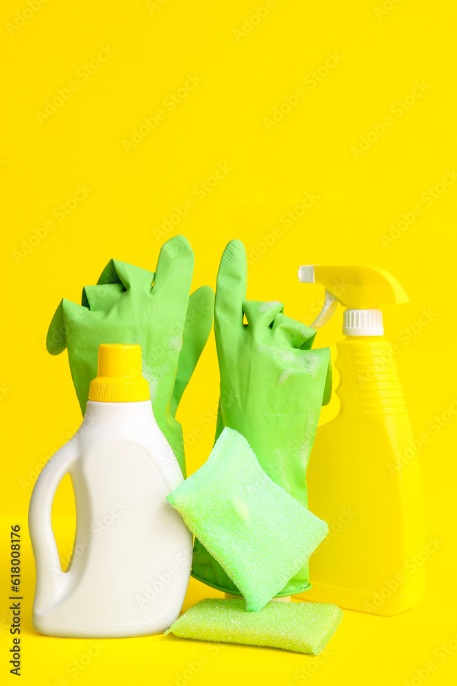 Different cleaning supplies on yellow background