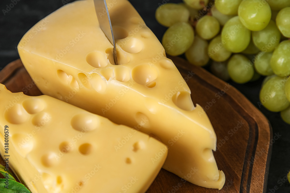 Board with tasty Swiss cheese on table