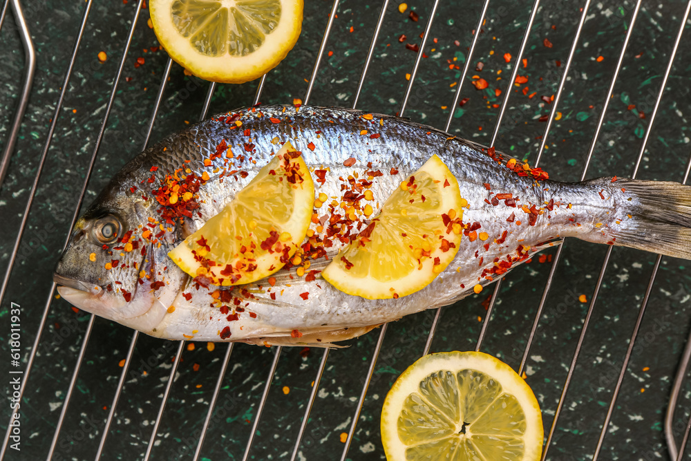 Cooling rack of raw dorado fish with lemon on table