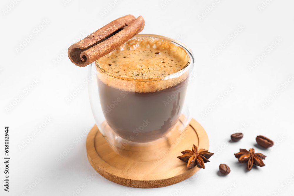 Glass cup of hot espresso with cinnamon on white background