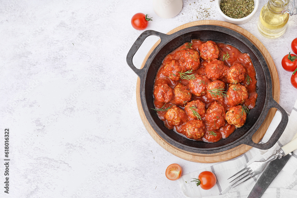 Frying pan of tasty meat balls with tomato sauce and dill on white background