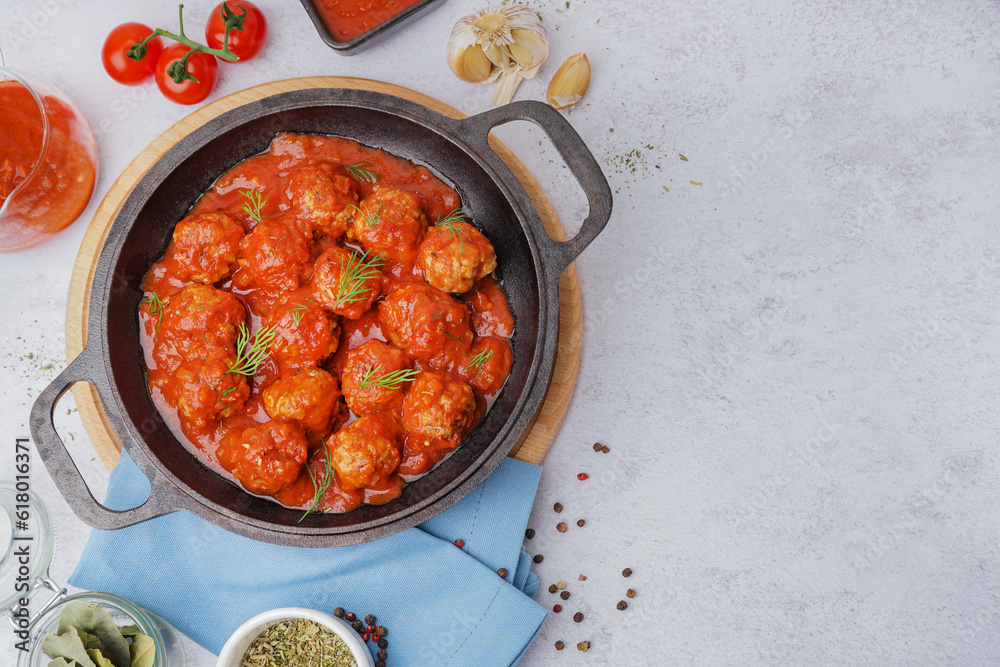 Frying pan of tasty meat balls with tomato sauce and dill on white background