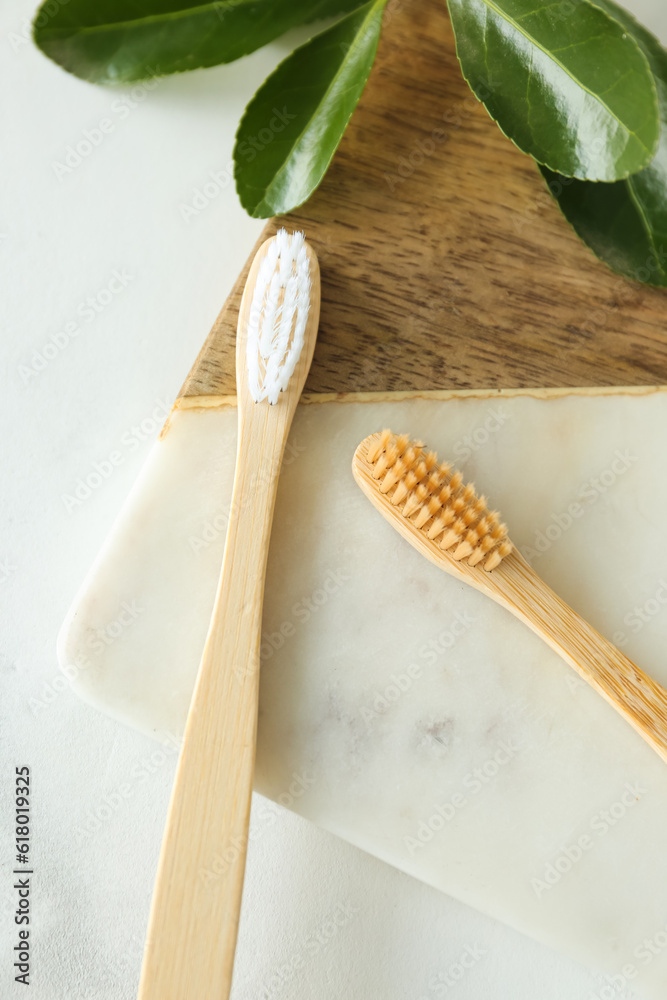 Bamboo tooth brushes on light background, top view