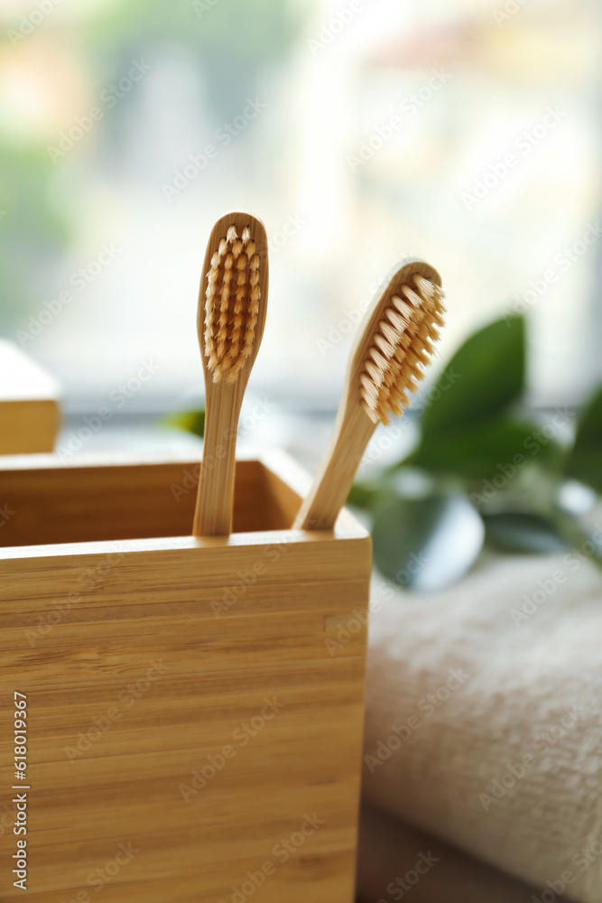 Holder with bamboo tooth brushes in bathroom, closeup