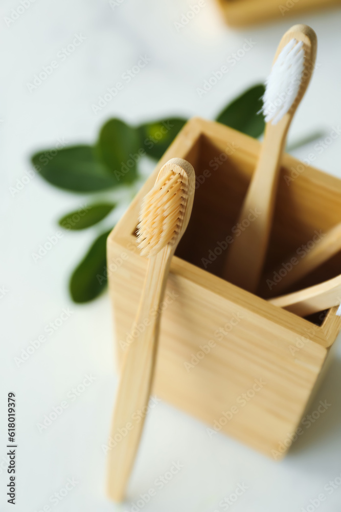 Holder with bamboo tooth brushes in bathroom, closeup