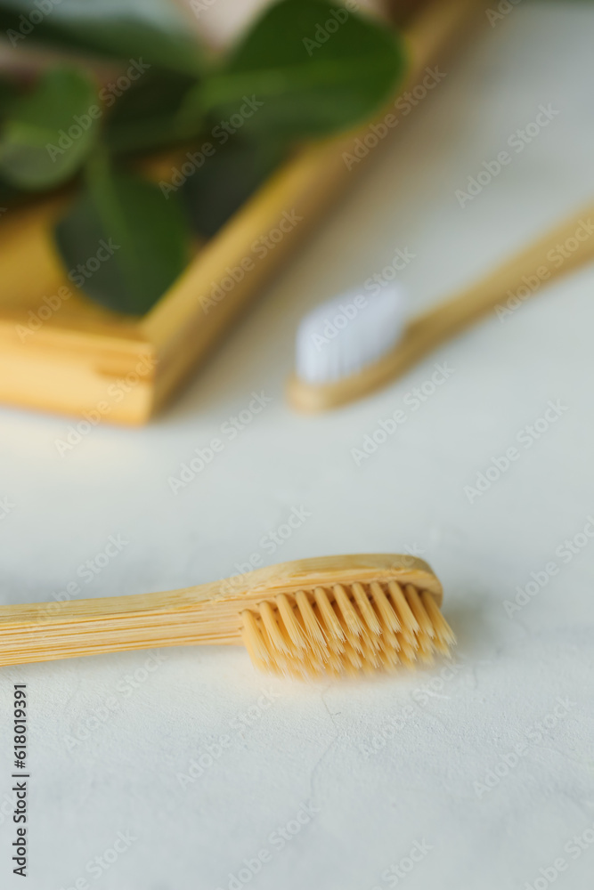 Bamboo tooth brushes on light background, closeup