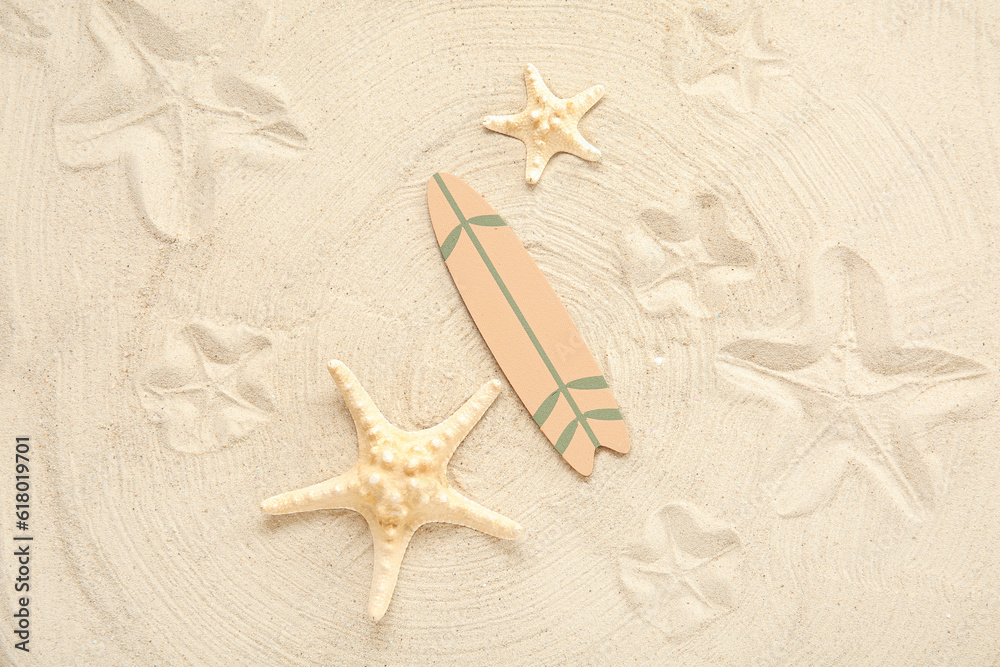 Mini surfboard with starfish on sand