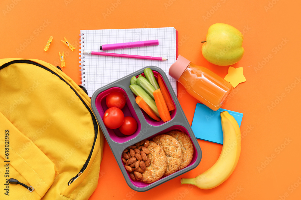 Backpack, stationery and lunch box with tasty food on orange background