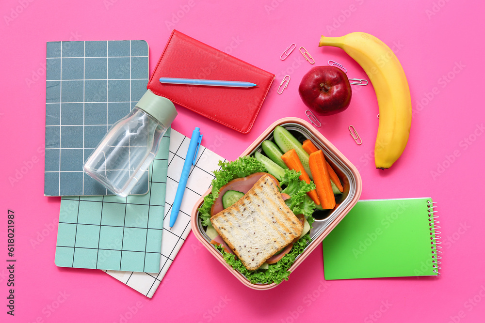 Different stationery, drink and lunch box with tasty food on pink background