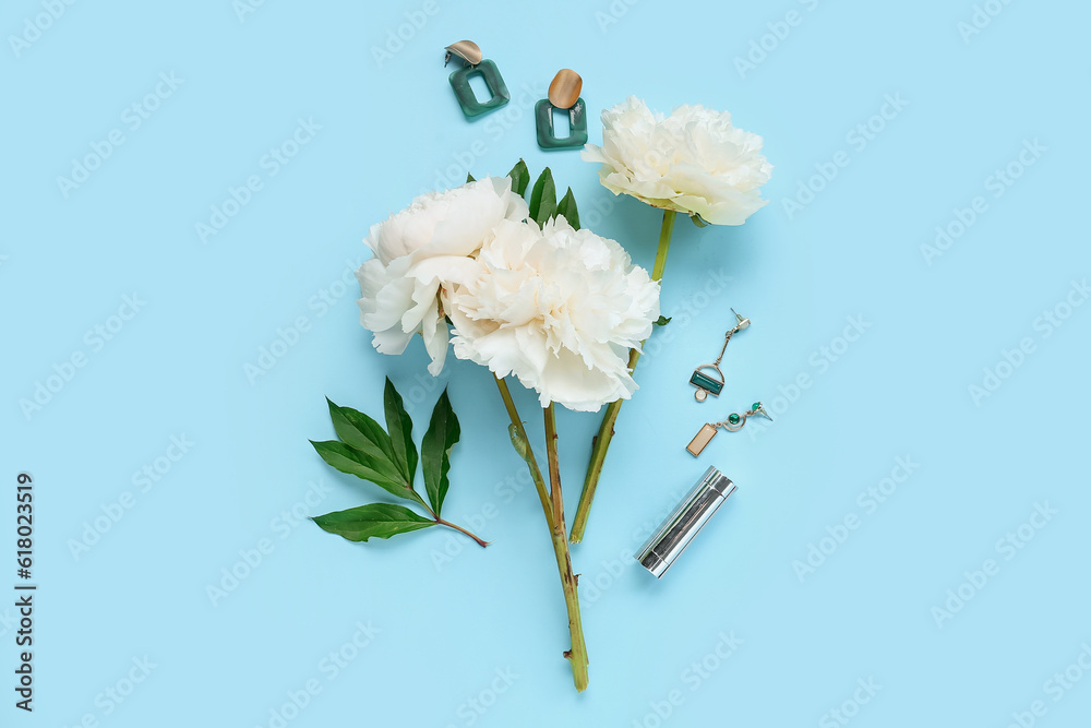 Composition with beautiful peony flowers, earrings and lipstick on color background