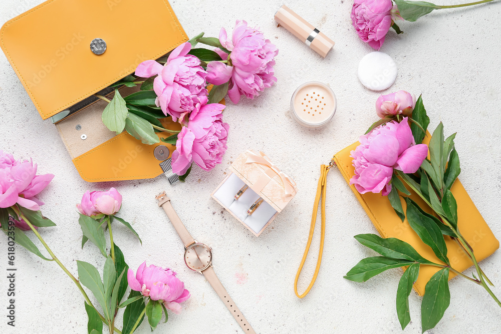 Composition with wedding rings, female accessories, cosmetics and beautiful peony flowers on light b