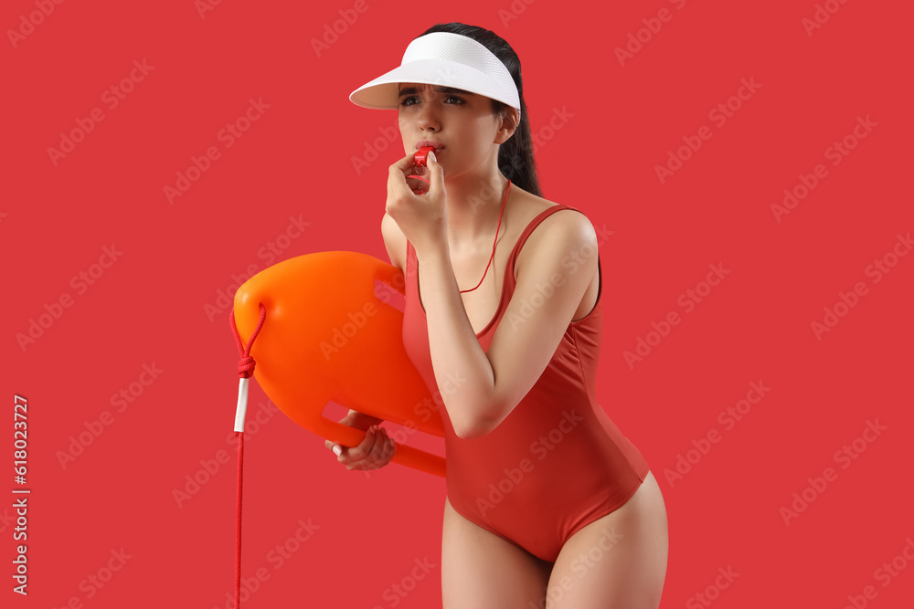 Female lifeguard with board whistling on red background