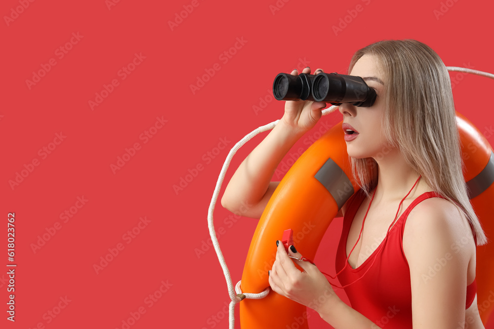 Female lifeguard with binoculars, whistle and ring buoy on red background