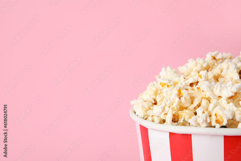 Bucket with tasty popcorn on pink background, closeup