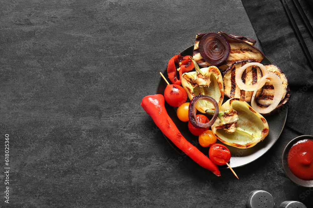 Plate with tasty grilled vegetables on black background