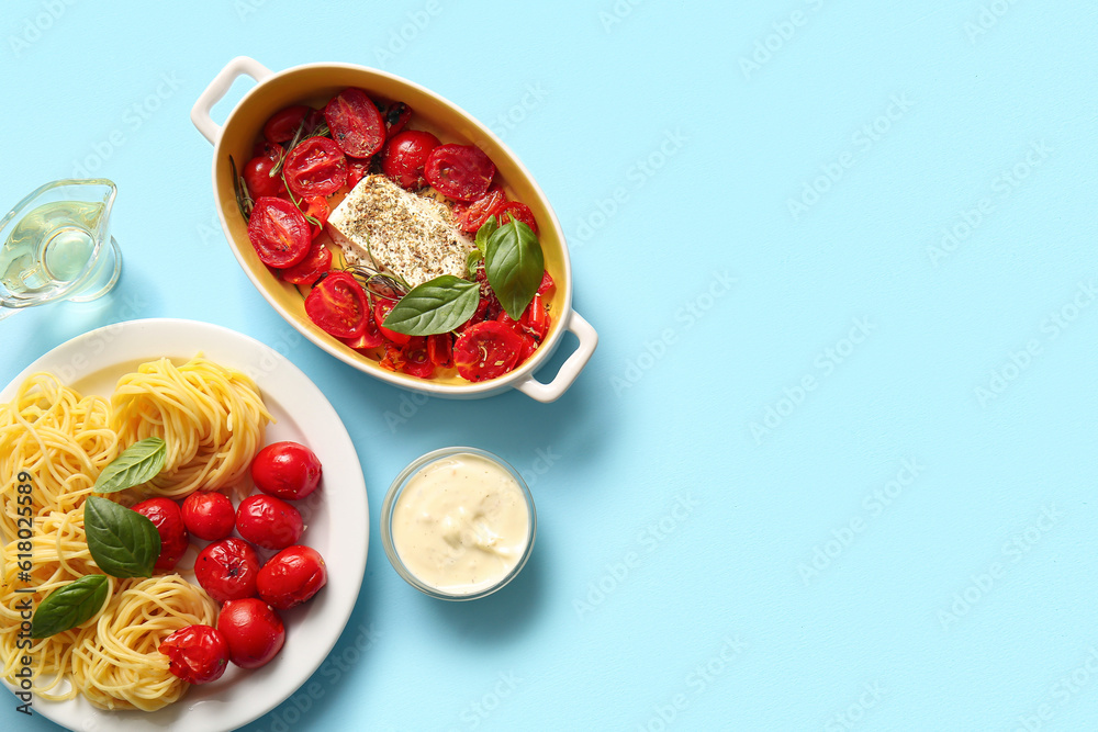 Baking dish with tasty tomatoes, feta cheese and pasta on blue background